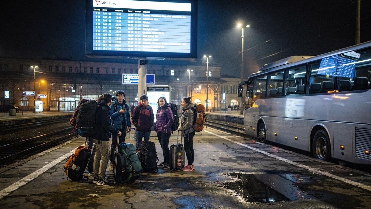 Night bus platform at Lviv station with a departure board and travellers waiting